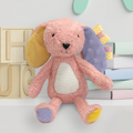 Pink plush toy with colorful accents on a white surface with wooden letters and pastel books in the background.