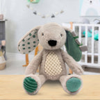 Stuffed toy rabbit with green accents on a wooden surface in a nursery setting