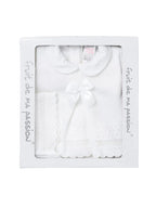 A white baby outfit set in its original white packaging box, featuring a short-sleeve knit top with a Peter Pan collar and a matching knitted bow, alongside a knitted bootie.