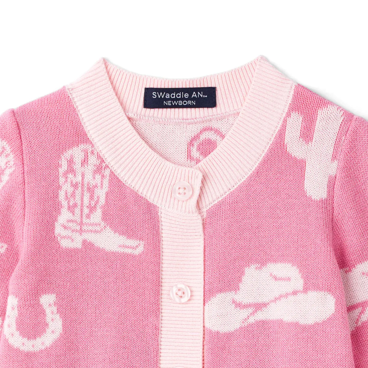 Pink baby romper with cowboy boot and hat patterns on a white background