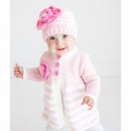 Baby wearing a pink knitted hat and scarf on a white background