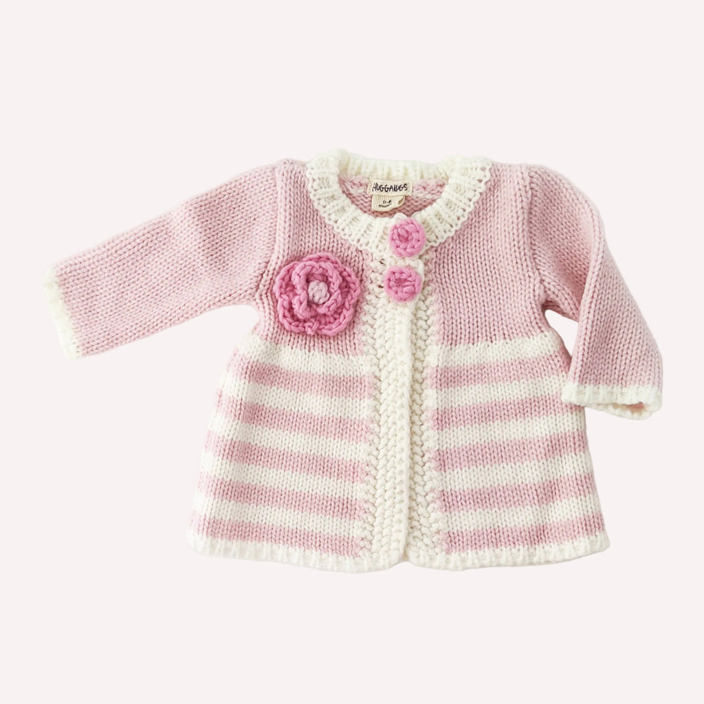 Pink and white striped baby sweater with a flower design on a white background