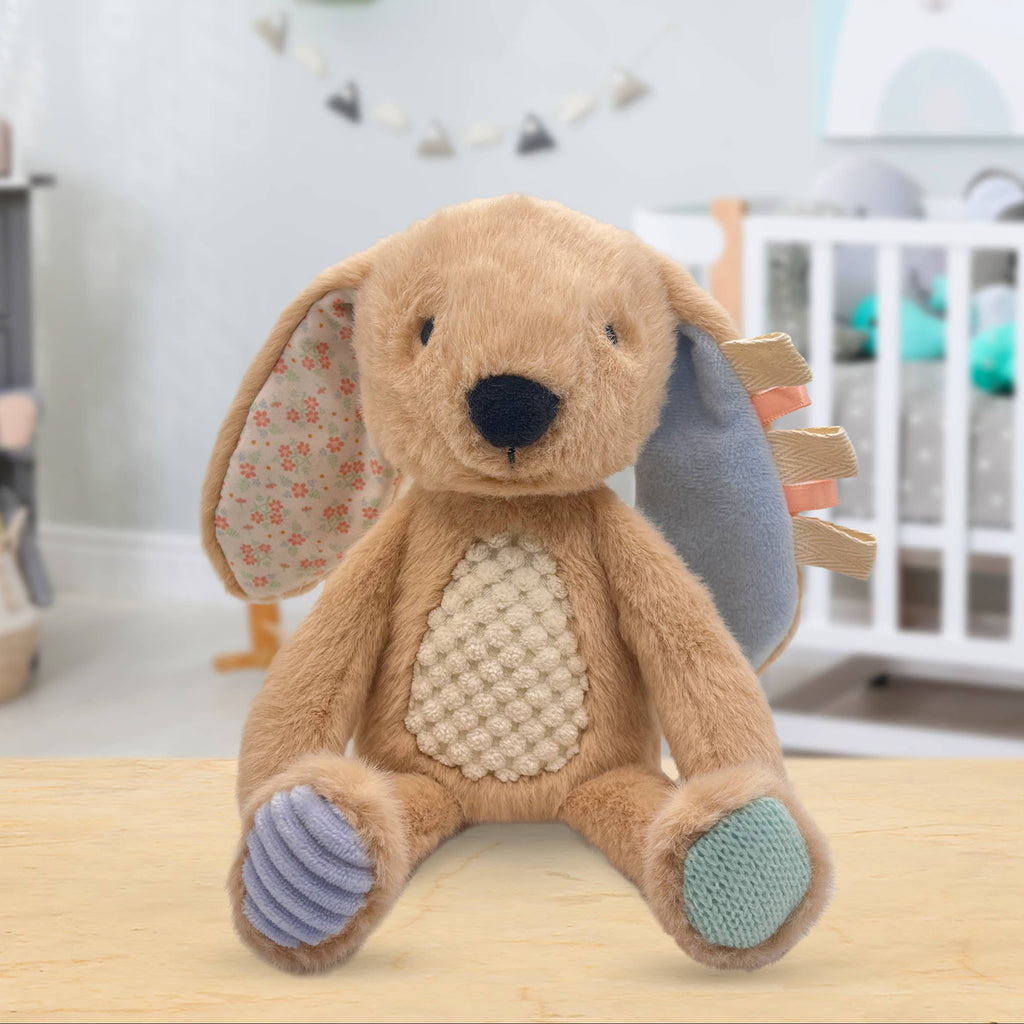 Brown plush toy with floral ears on a wooden surface in a nursery setting