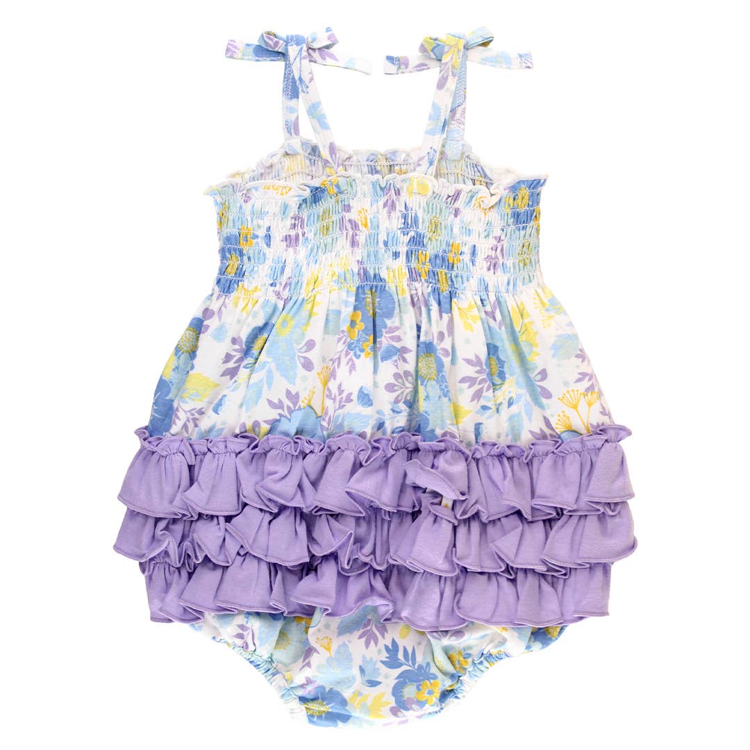 Baby romper with floral top and ruffled bottom on a white background