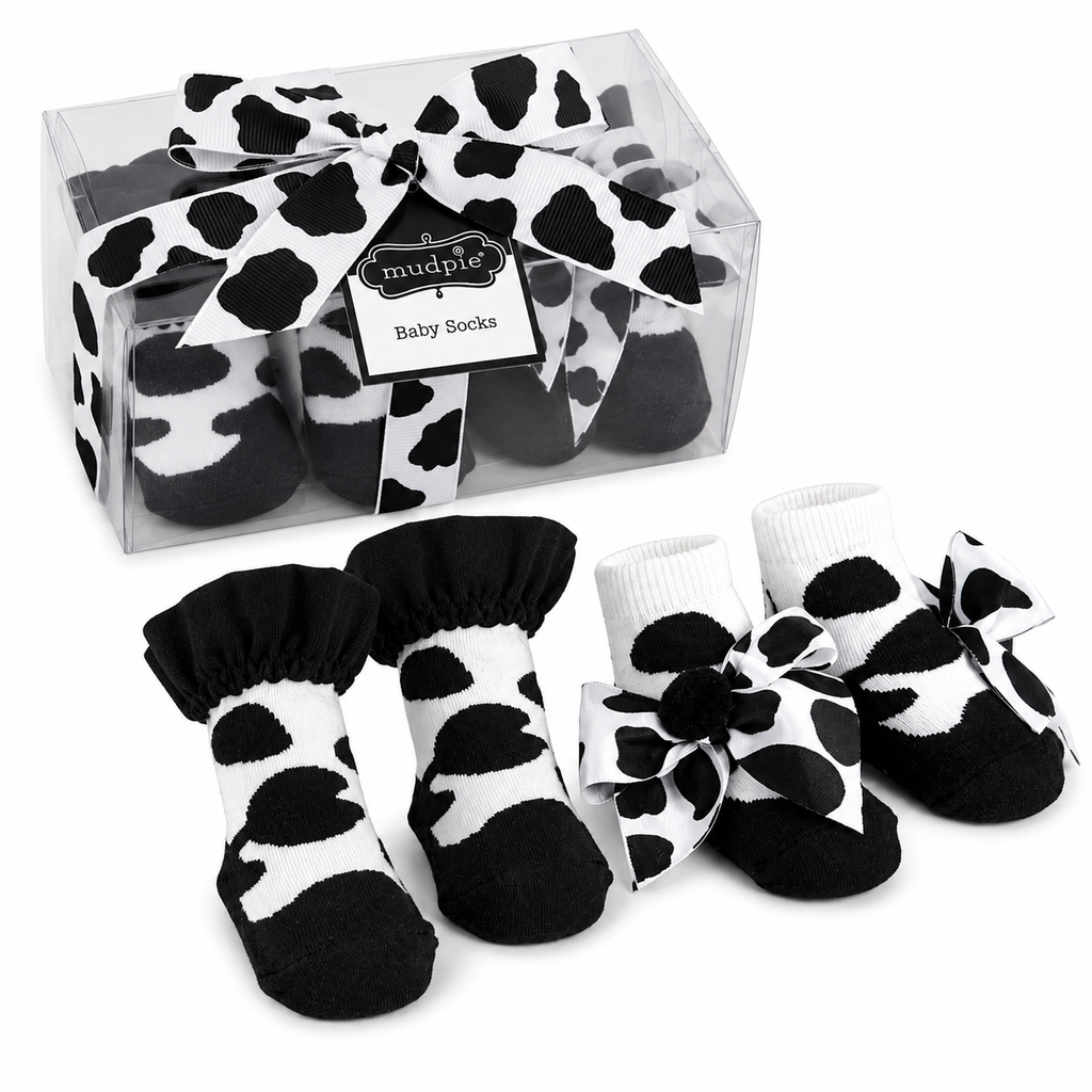 Cow print baby socks with a clear packaging box on a white |background | AdoraBaby.co.uk