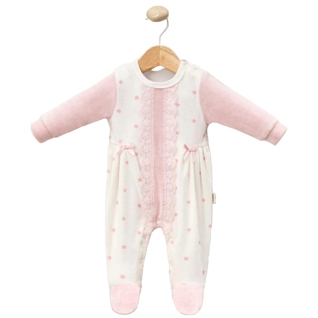 Baby onesie with pink dots & lace on a wooden hanger against a white background