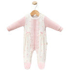 Baby onesie with pink dots & lace on a wooden hanger against a white background