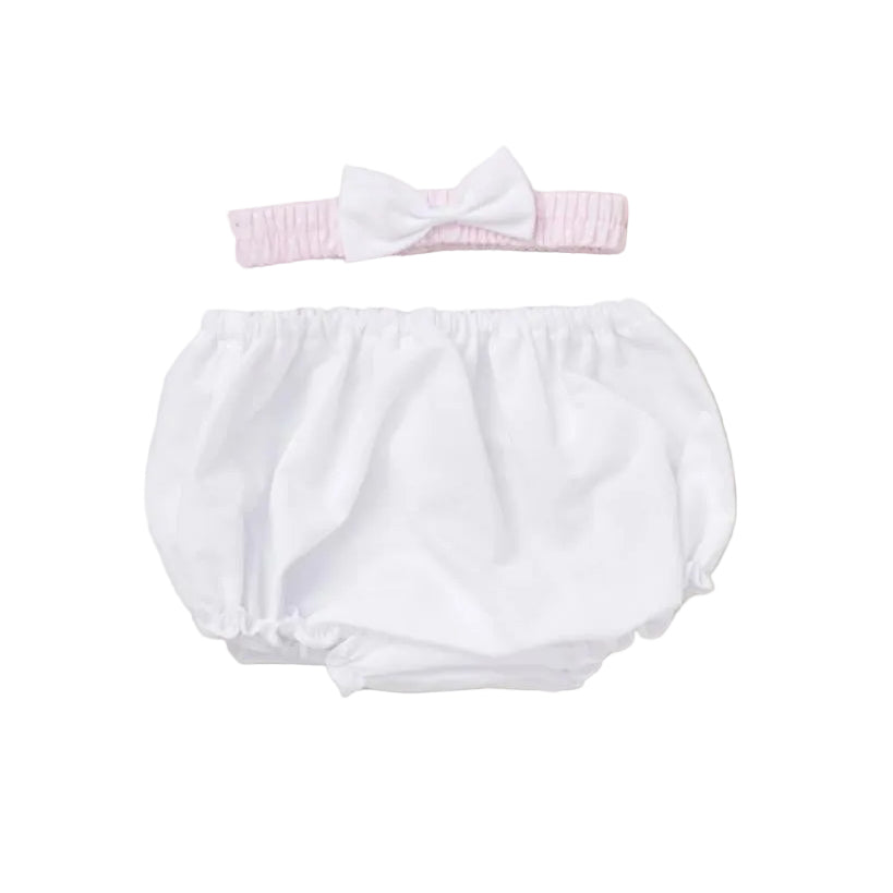 White baby bloomers with a pink headband on a beige background
