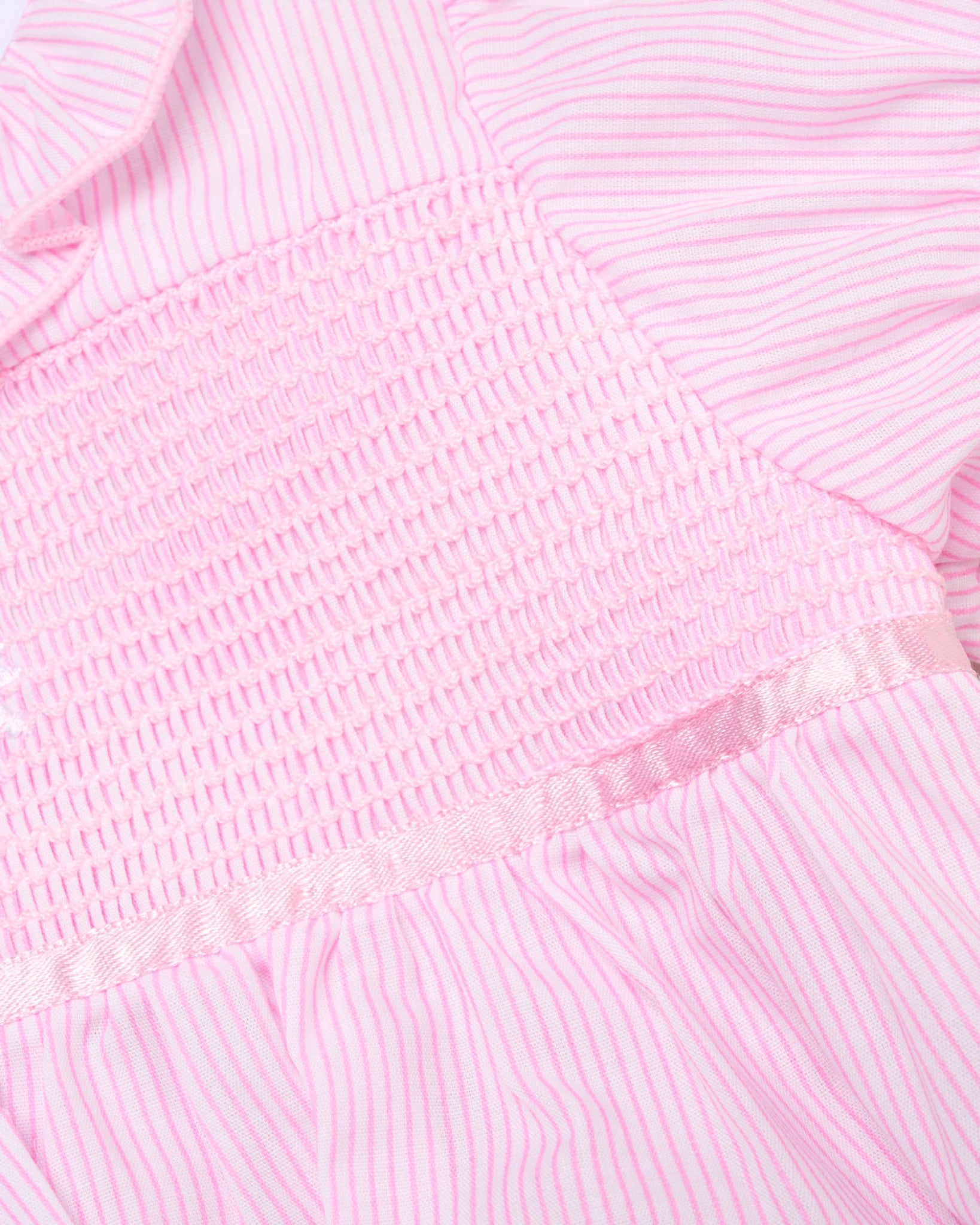 Close-up of a pink textured fabric with a subtle pattern
