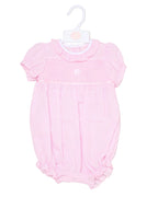 Pink baby romper on a hanger against a beige background