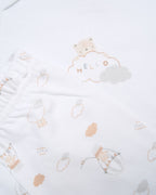White baby onesie with a small design on a beige background - Adorababy.co.uk