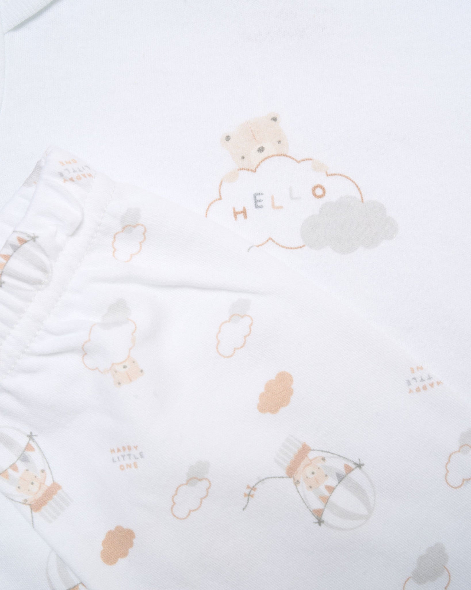 White baby onesie with a small design on a beige background - Adorababy.co.uk