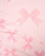 Close-up of pink fabric with bow pattern