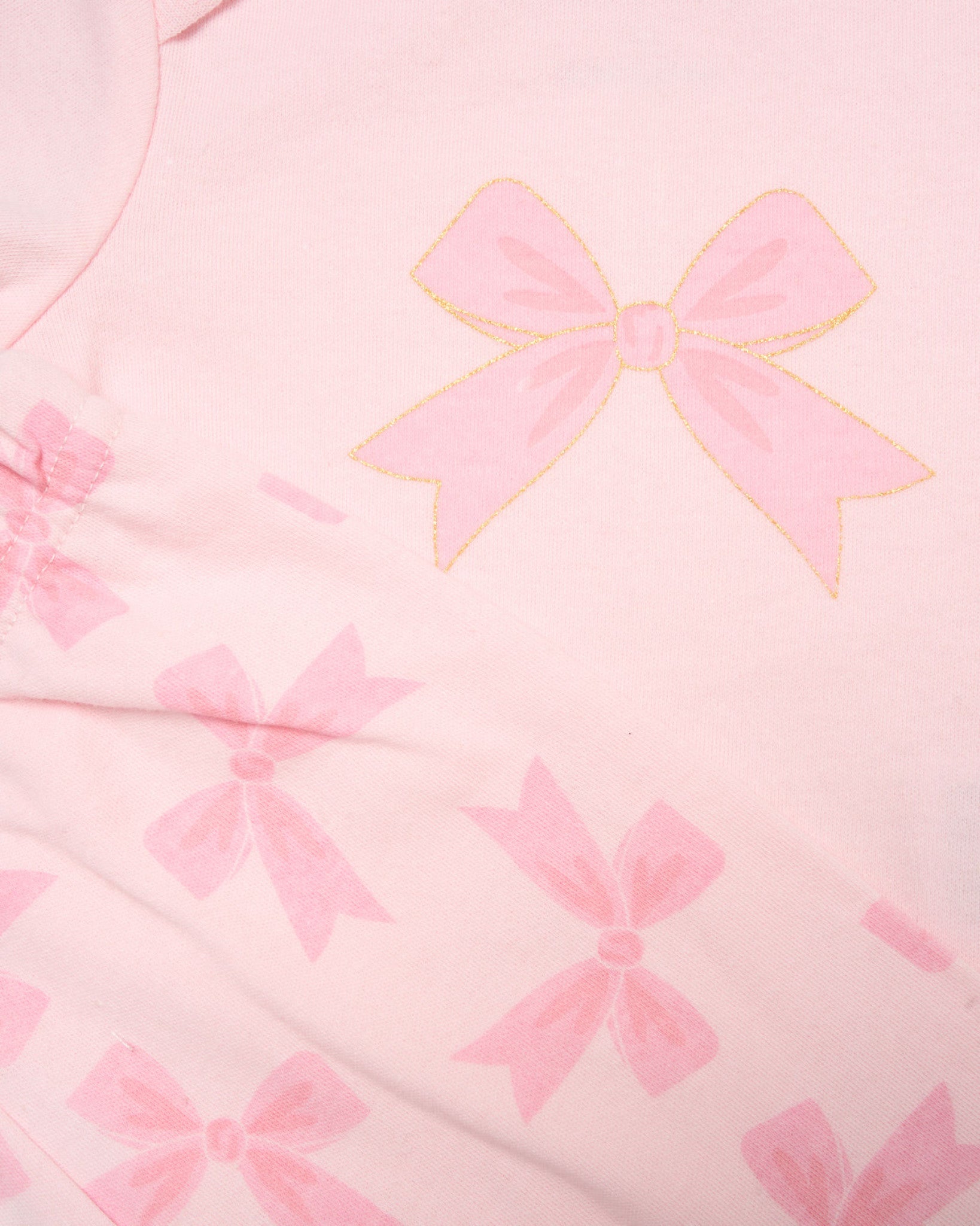 Close-up of pink fabric with bow pattern