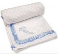 White baby blanket with blue ruffle and 'Prince' embroidery on a white background