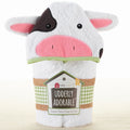 White Cow-shaped hooded towel with pink face and black ears, featuring a label on a white background.