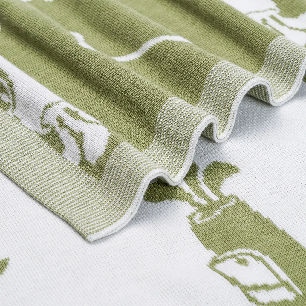 Close-up of a green and white patterned baby blanket with golf embroidery
