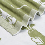 Close-up of a green and white patterned baby blanket with golf embroidery