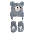 A baby winter hat and bootie set in dusty blue-gray. The knit hat features a bear face with a white snout, black nose, orange cheeks, and fluffy pom-poms on top.