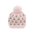 A light pink hand-knit beanie hat with a matching pom-pom on top, featuring a repeating pattern of pink and white tulips with green leaves, shown against a plain white background.