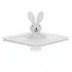 White plush bunny toy on a textured white blanket