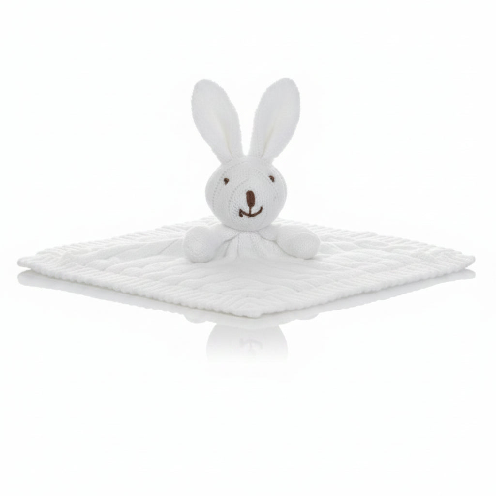 White plush bunny toy on a textured white blanket