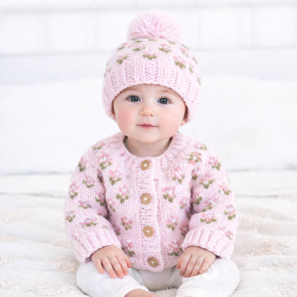 Baby wearing a Huggalugs hand Knitted baby cardigan and hat with pink floral pattern - Aodrababy.co.uk