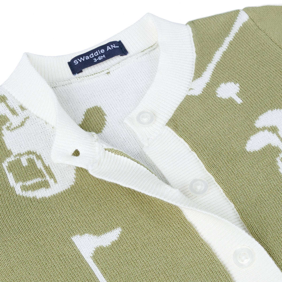Close-up of a knit polo shirt by Swaddle AN. featuring an olive green and white golf-themed pattern with a white ribbed collar and button placket.