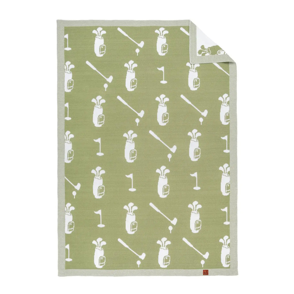 A rectangular golf-themed baby blanket with a sage green background and a white repeating pattern of golf bags, clubs, flags, and tees, shown on a plain white background with one corner folded over.