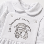 White baby outfit with embroidered design and text on a white background