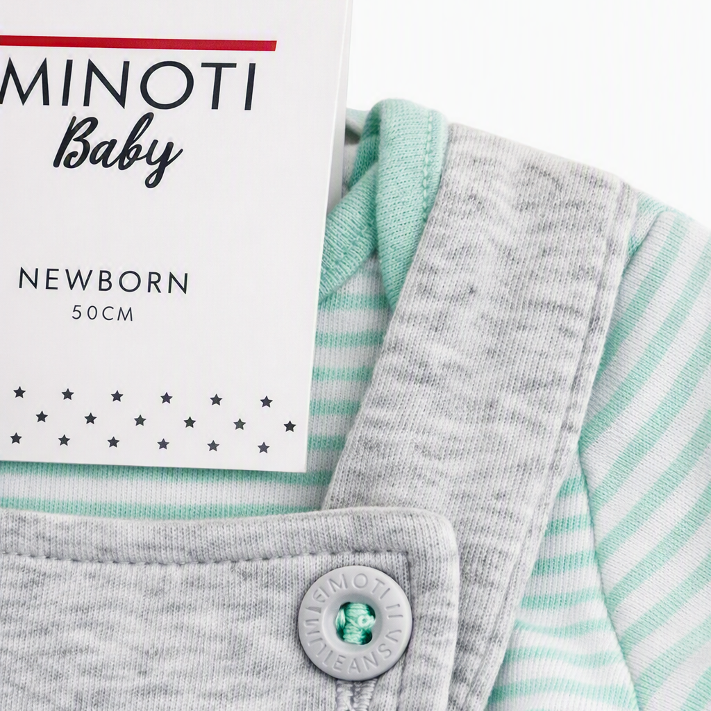 A close-up of a baby outfit featuring a light gray bib or overalls layered over a mint green and white striped long-sleeve top. A white tag reading 'MINOTI Baby NEWBORN 50CM' is attached near the collar, and a small 'Made with AI' watermark appears in the top right corner.
