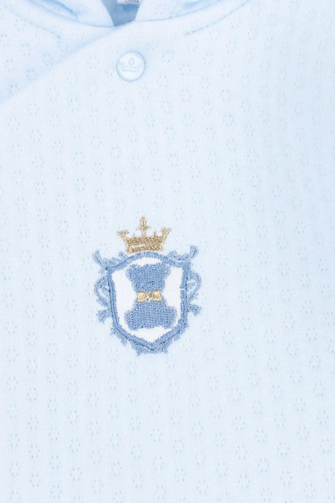 Embroidered crest on a light blue fabric background - Adorababy.co.uk