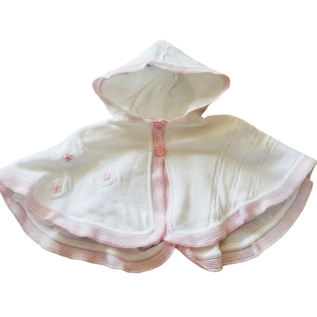 A white hooded baby cape or poncho with pink trim and buttons, displayed against a plain white background. - Adorababy.co.uk